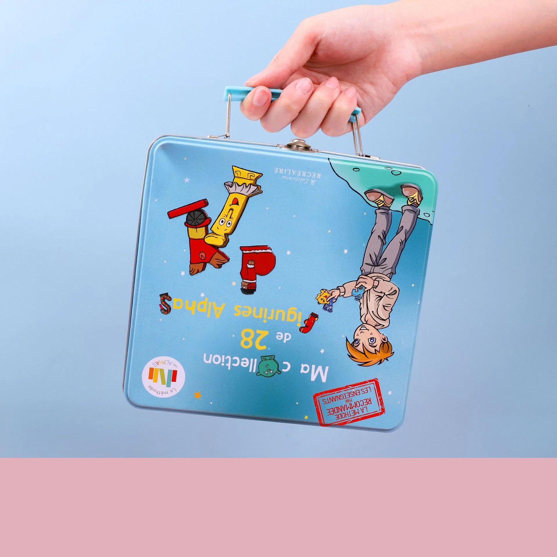 Caja azul de transporte del juego de letras de PVC con alfabeto animal sostenida con una mano