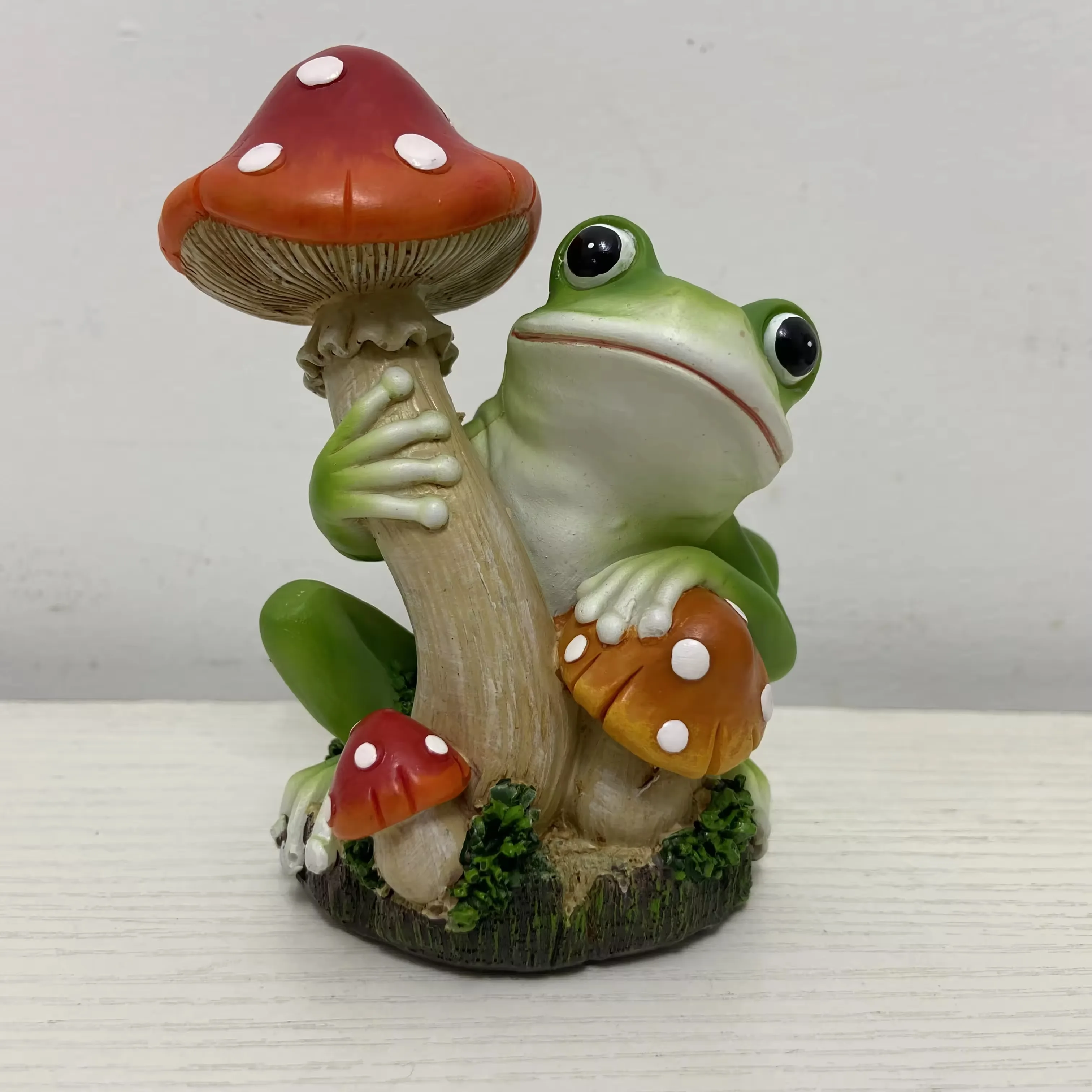Best-selling hand-painted resin frog figurine leaning against a red mushroom for garden decor and gift displays