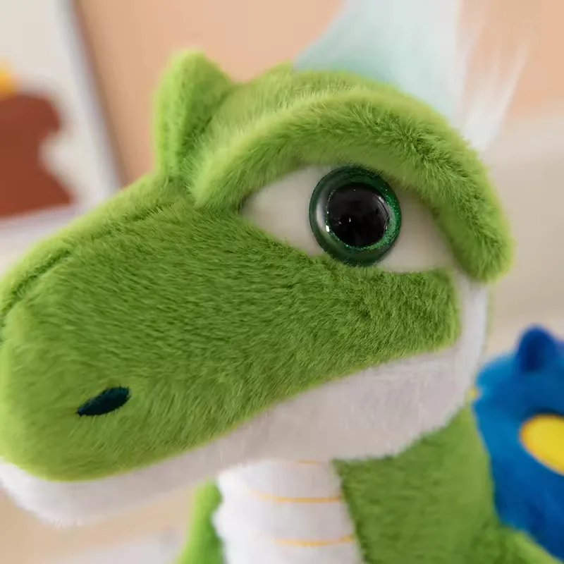 Primer plano del rostro del dinosaurio de peluche verde con ojo brillante, hocico redondeado y línea de mandíbula blanca