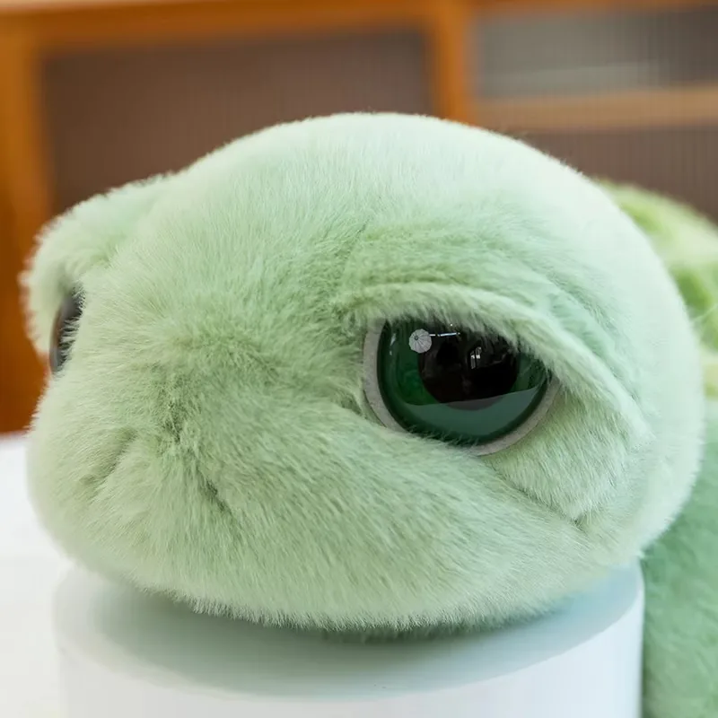 Primer plano de la cara del peluche de tortuga de ojos grandes con pelo verde menta y ojo verde oscuro brillante
