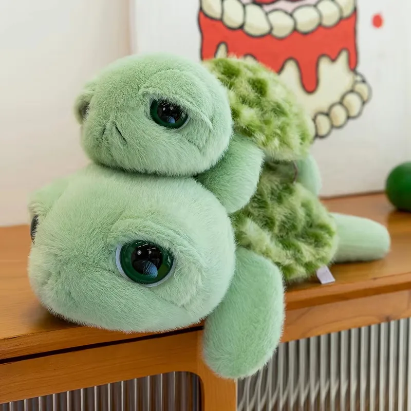 Dos peluches de tortuga de ojos grandes apilados para mostrar la cara redondeada y la textura del caparazón
