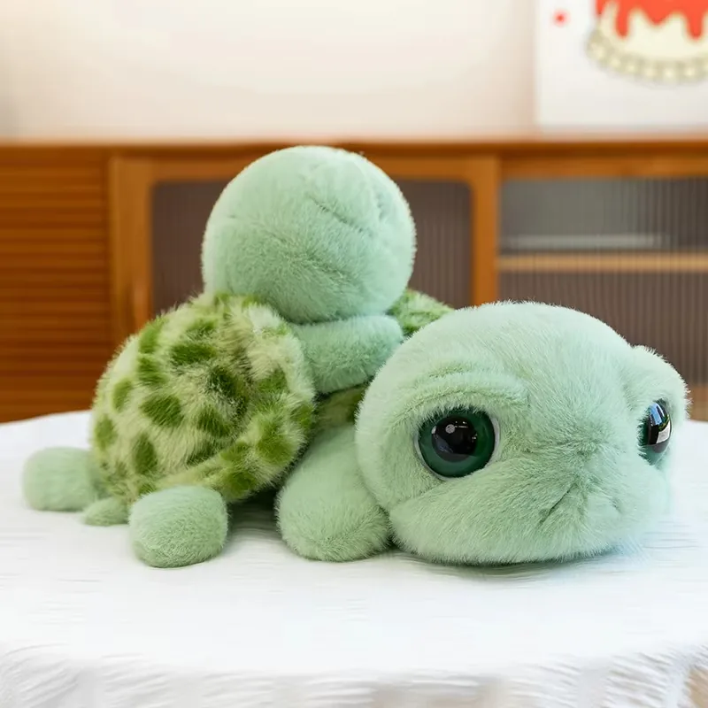 Vista en ángulo lateral del peluche de tortuga de ojos grandes con un ojo, el caparazón y la aleta frontal visibles