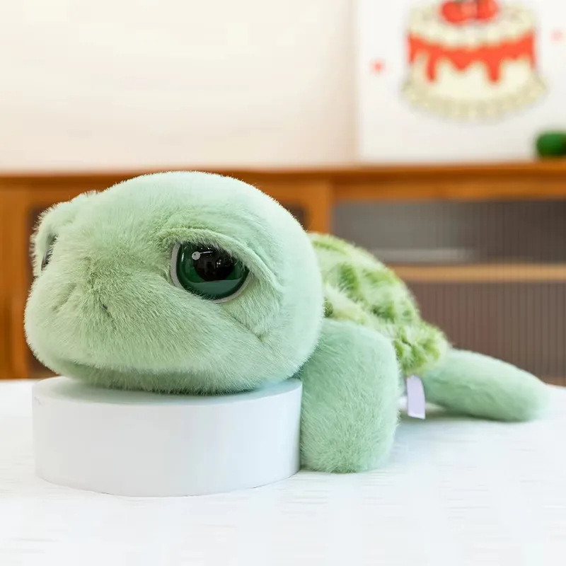 Vista lateral del peluche de tortuga de ojos grandes apoyado bajo con cabeza redondeada y aletas suaves