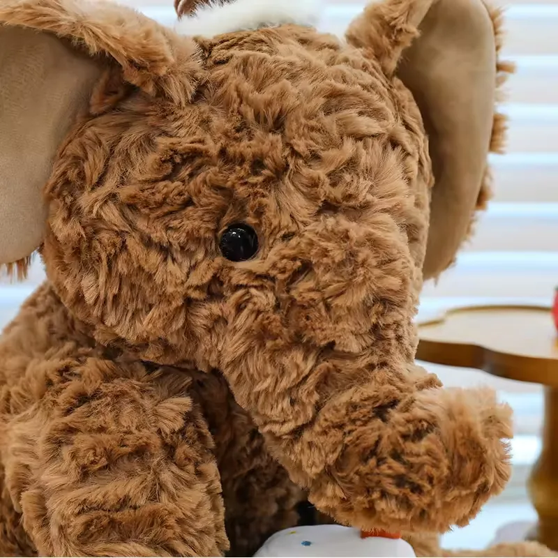 Primer plano del elefante de peluche de cumpleaños marrón destacando la textura rizada y la trompa redondeada