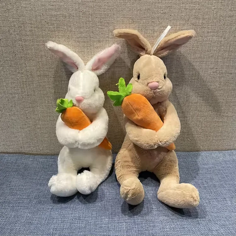 Peluches de conejo blanco y beige sentados rectos mientras sostienen zanahorias contra el pecho