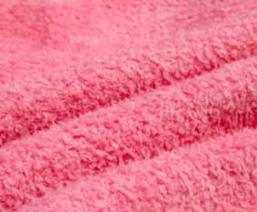 Close-up van roze coral fleece met een pluizige, behaaglijke textuur en een dekenachtig gevoel