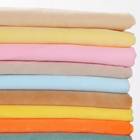 Stack of minky plush fabric swatches in multiple colors showing soft pile texture and color variety