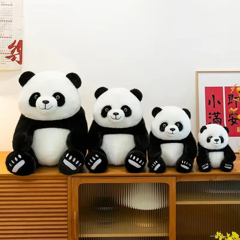 Cuatro peluches de panda sentados ordenados de mayor a menor como una colección coordinada de tamaños