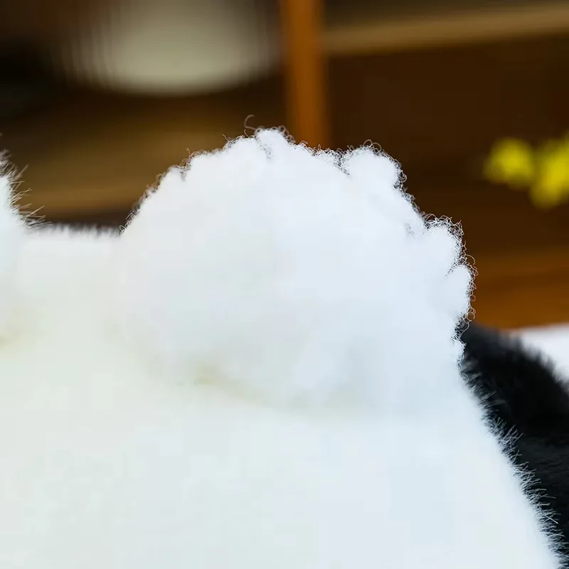 Detalle de la cola blanca y suave del peluche de panda en la parte trasera del cuerpo sentado