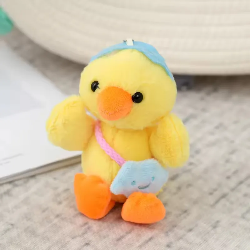 Peluche de pato colgante para mochila en amarillo con gorra azul y mini bolso estrella azul