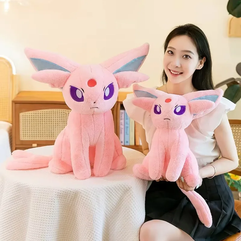 Modelo sosteniendo dos peluches Espeon de diferentes tallas para programas de regalo y exhibición
