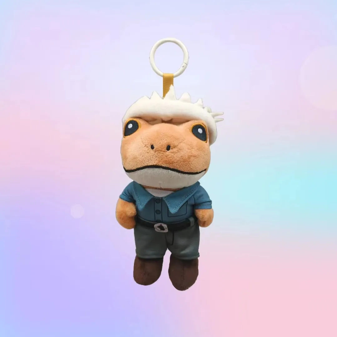 Llavero de rana de peluche con mechón blanco, camiseta azul, pantalones oscuros y botas marrones