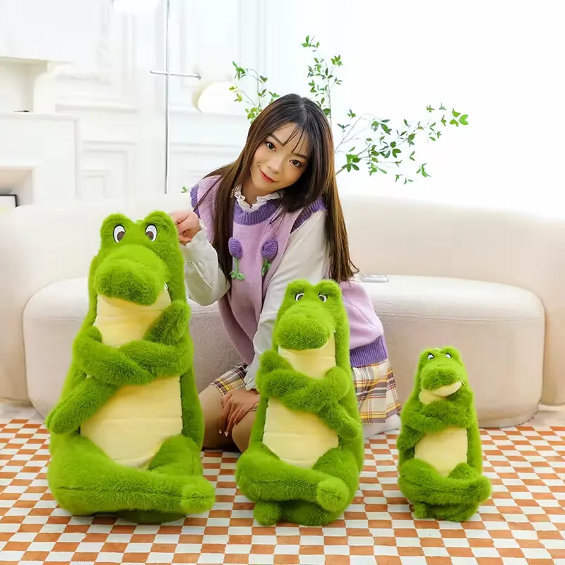 Three green crocodile plush dolls shown in a size family with crossed arms, long legs, and cream belly panels