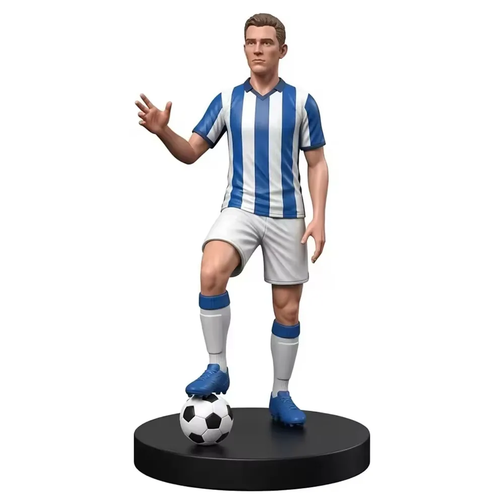 Escultura de estrella del futbol en resina pintada a mano con uniforme azul y blanco a rayas, pose de saludo y base negra de display