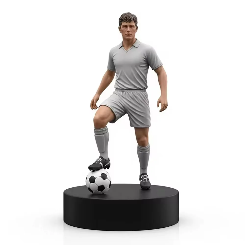 Figurine de jugador de futbol en resina pintada a mano con uniforme gris sobre una base negra conmemorativa