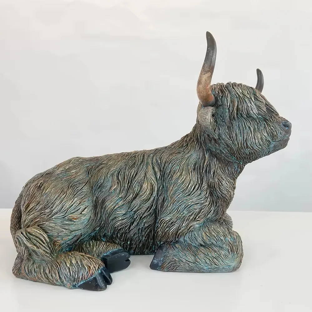 Figura de vaca Highland reclinada en resina con textura de pelaje en capas y cuernos elevados vista desde el lado derecho