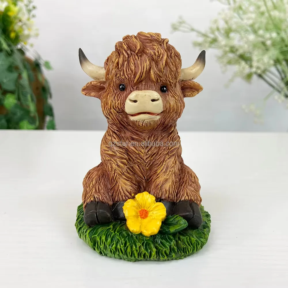 Vista frontal de una figura de ternero Highland en resina sentado sobre una base de cesped con un acento floral amarillo