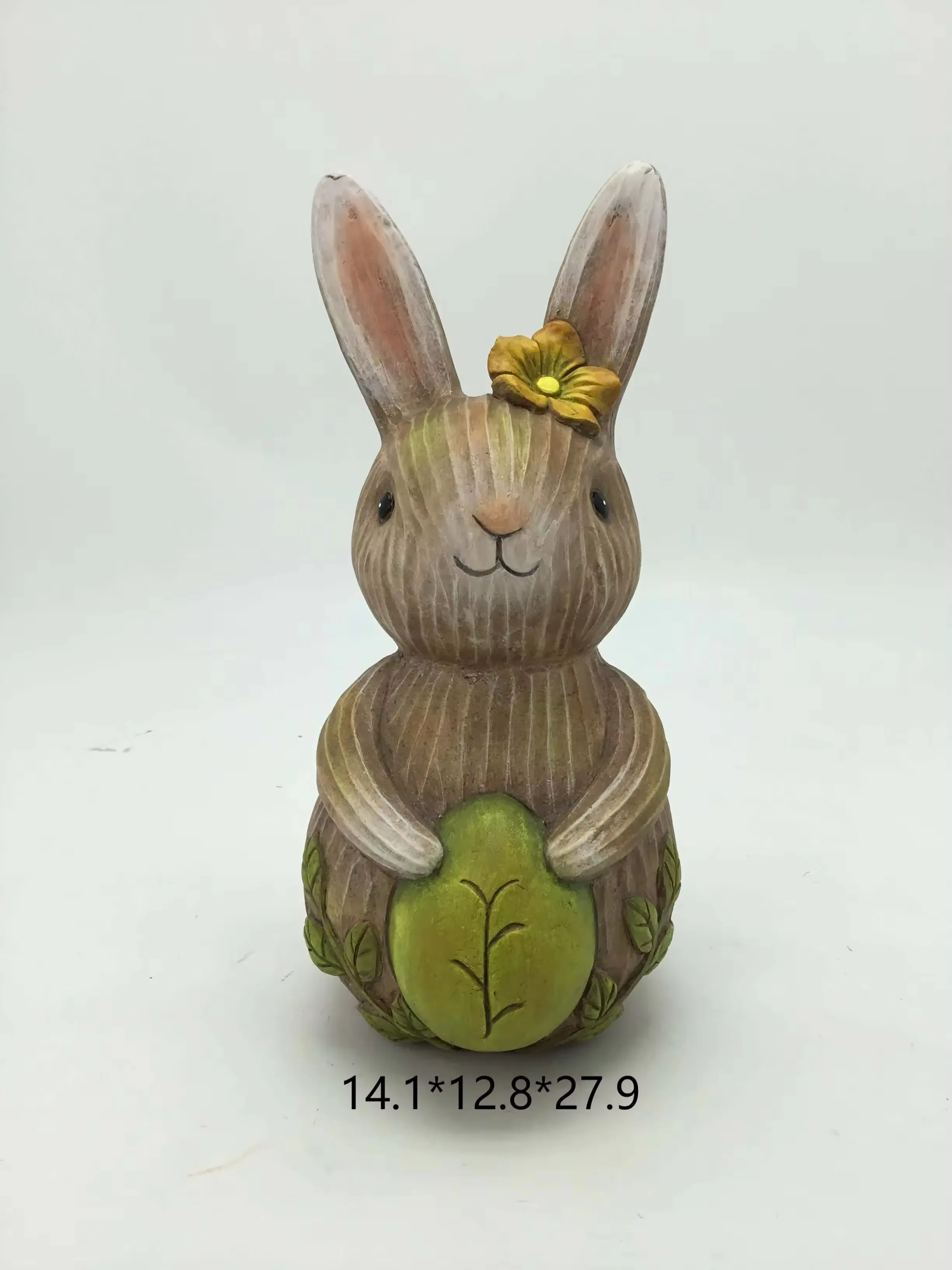 Figura de conejo primaveral en resina sosteniendo un huevo verde de Pascua con una flor sobre una oreja