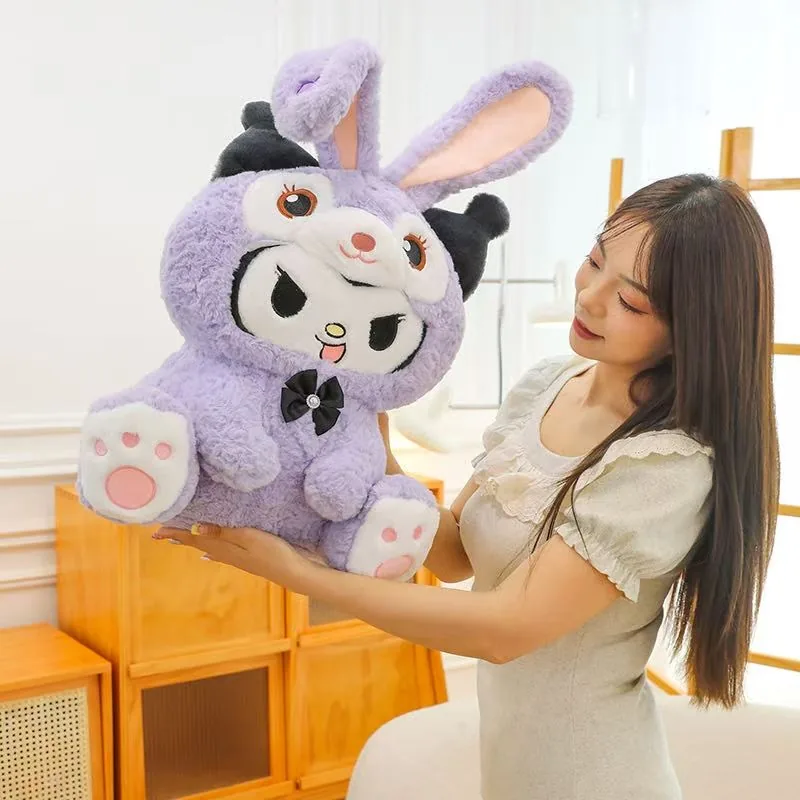 Mujer sosteniendo un gran peluche de conejo morado de Kuromi para mostrar la escala