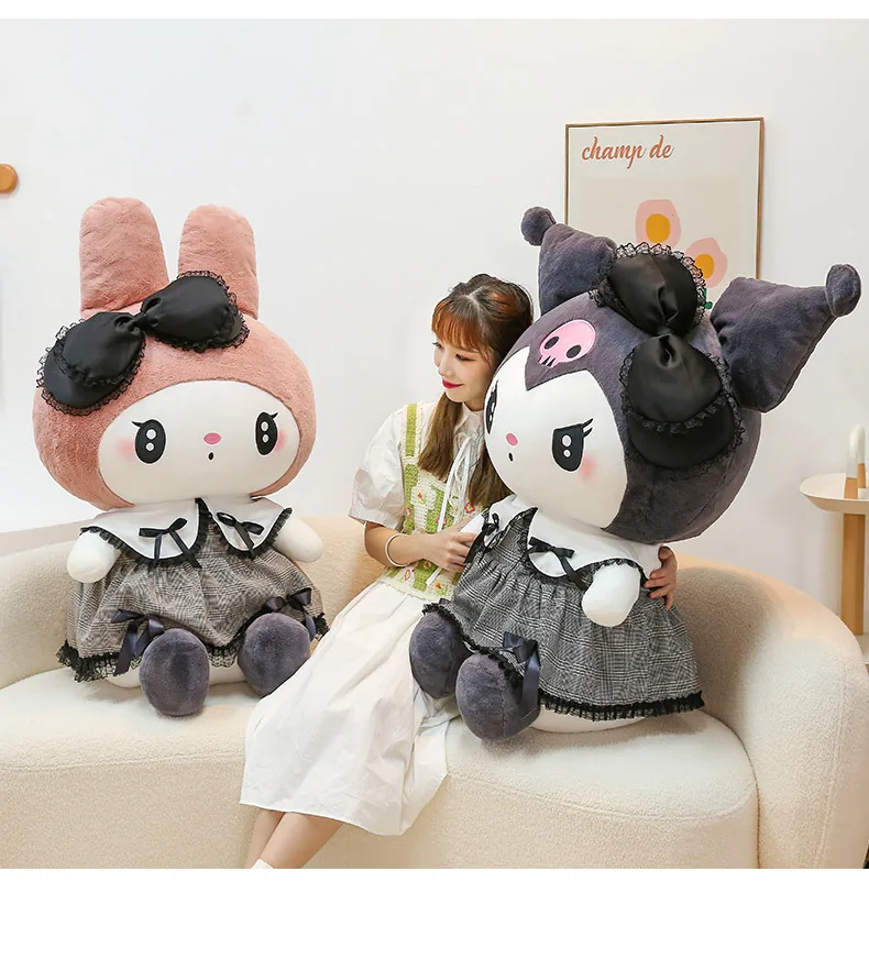 Peluches góticos de My Melody y Kuromi de gran tamaño expuestos juntos sobre un sofá junto a un modelo