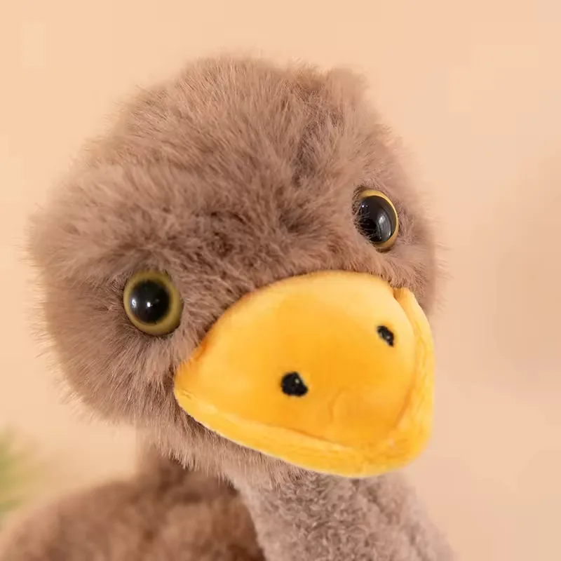Primer plano del rostro del peluche de avestruz con cabeza marrón esponjosa y pico amarillo suave