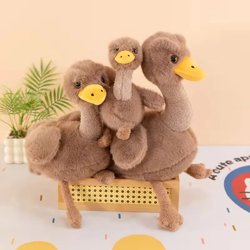 Peluches de avestruz grande, mediano y pequeño agrupados juntos en una banca de exhibición