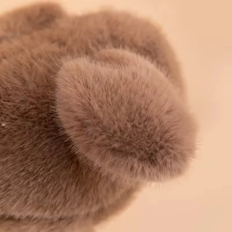 Detalle de ala redondeada y suave en el cuerpo marrón del peluche de avestruz