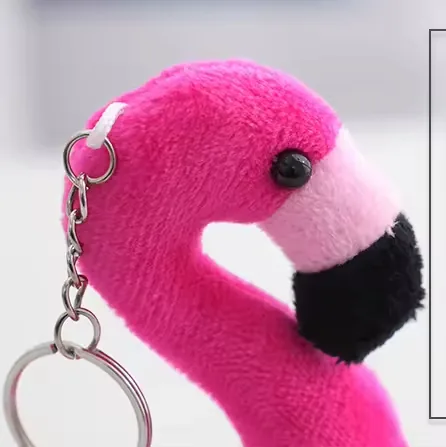 Primer plano del rostro del colgante de peluche llavero de flamenco rosa intenso con pico negro y ojo de cuenta