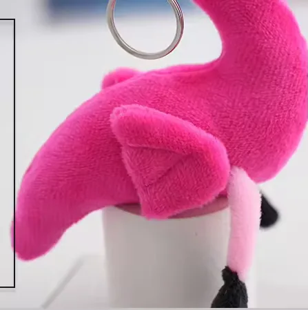 Primer plano del pequeño detalle del ala en el colgante de peluche llavero de flamenco rosa intenso