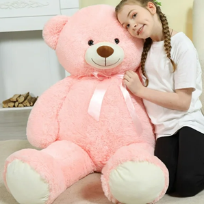 Young girl posing beside a giant pink teddy bear