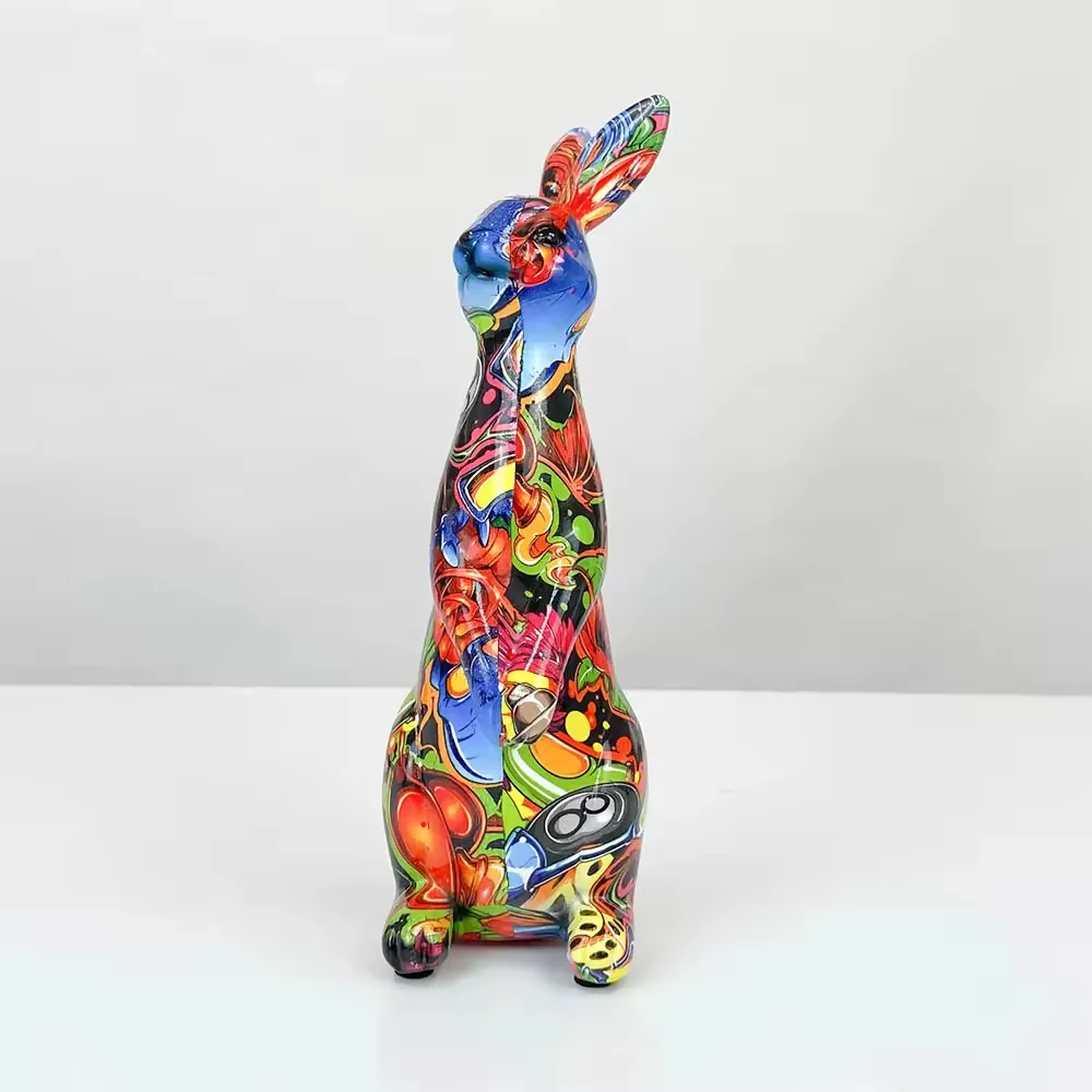 Vista frontal de una estatua de conejo pop art en resina brillante con graficos abstractos en azul, rojo, verde y negro