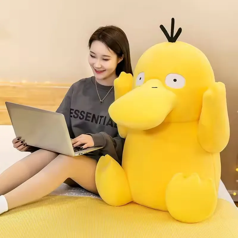 Peluche Psyduck grande junto a un modelo en una escena lifestyle de habitacion