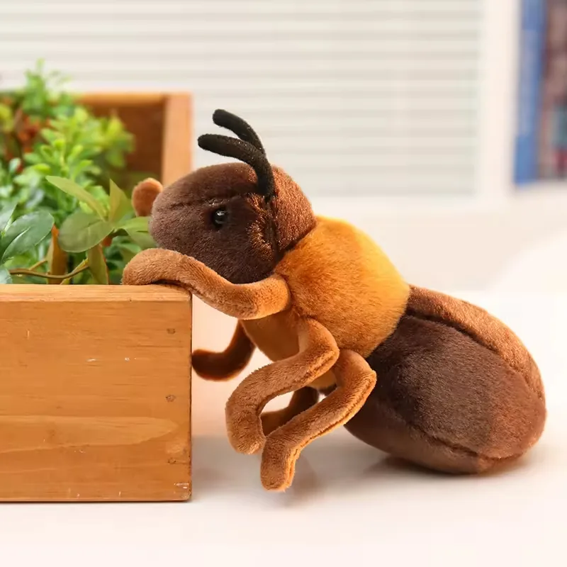 Vista lateral de un peluche de hormiga realista trepando junto a una jardinera de madera