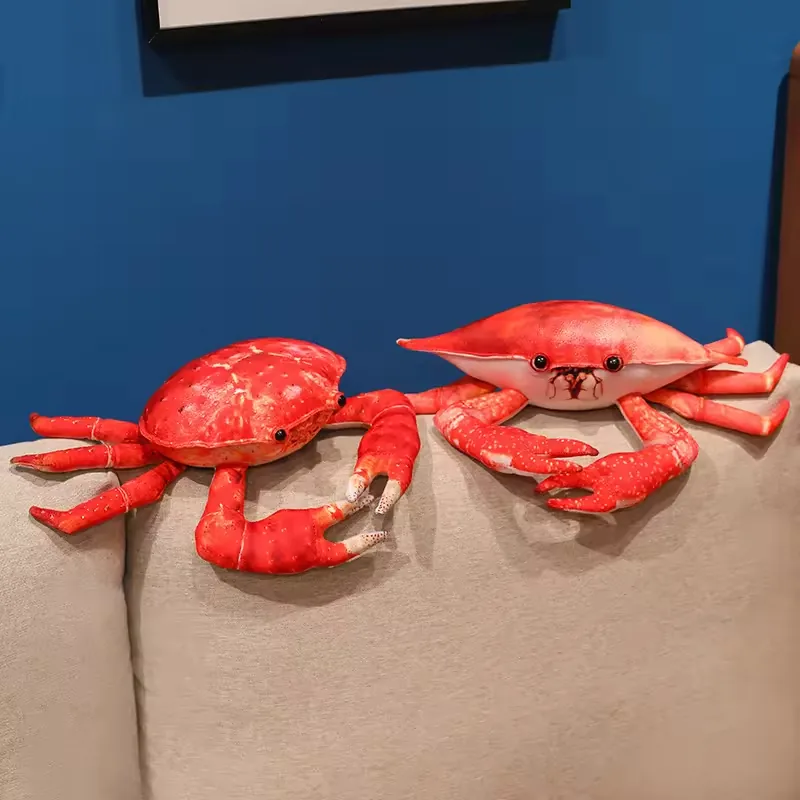 Dos peluches de cangrejo con estilos de caparazon distintos colocados juntos sobre el respaldo de un sofa