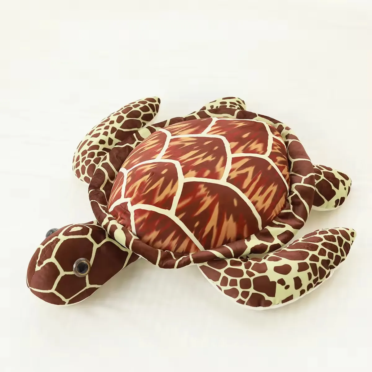 Almohada de peluche de tortuga marina realista marron con caparazon estampado, cabeza redondeada y aletas planas sobre fondo blanco