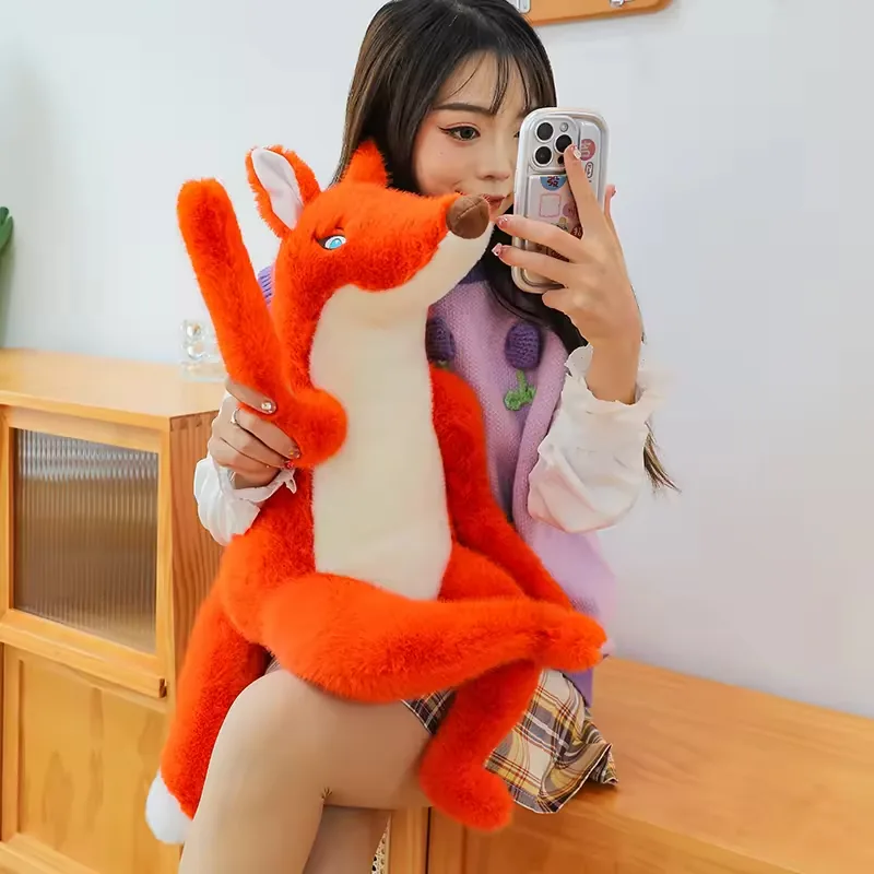 Una persona sujetando un peluche grande de zorro rojo por delante para mostrar la altura del cuerpo y la escala de patas largas
