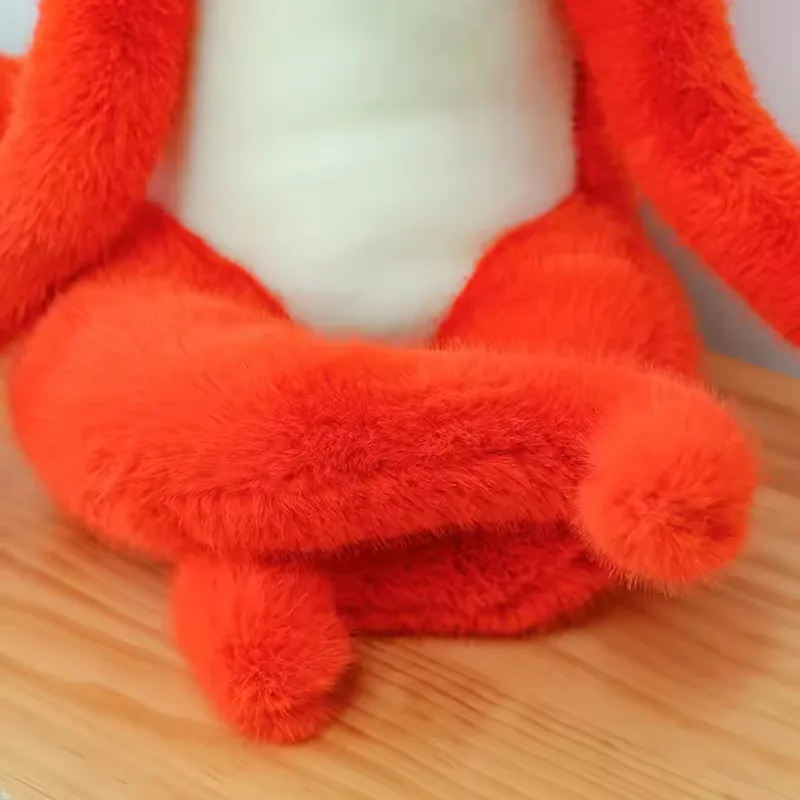 Primer plano de las patas cruzadas y suaves del peluche de zorro rojo con panel blanco en el vientre en postura sentada