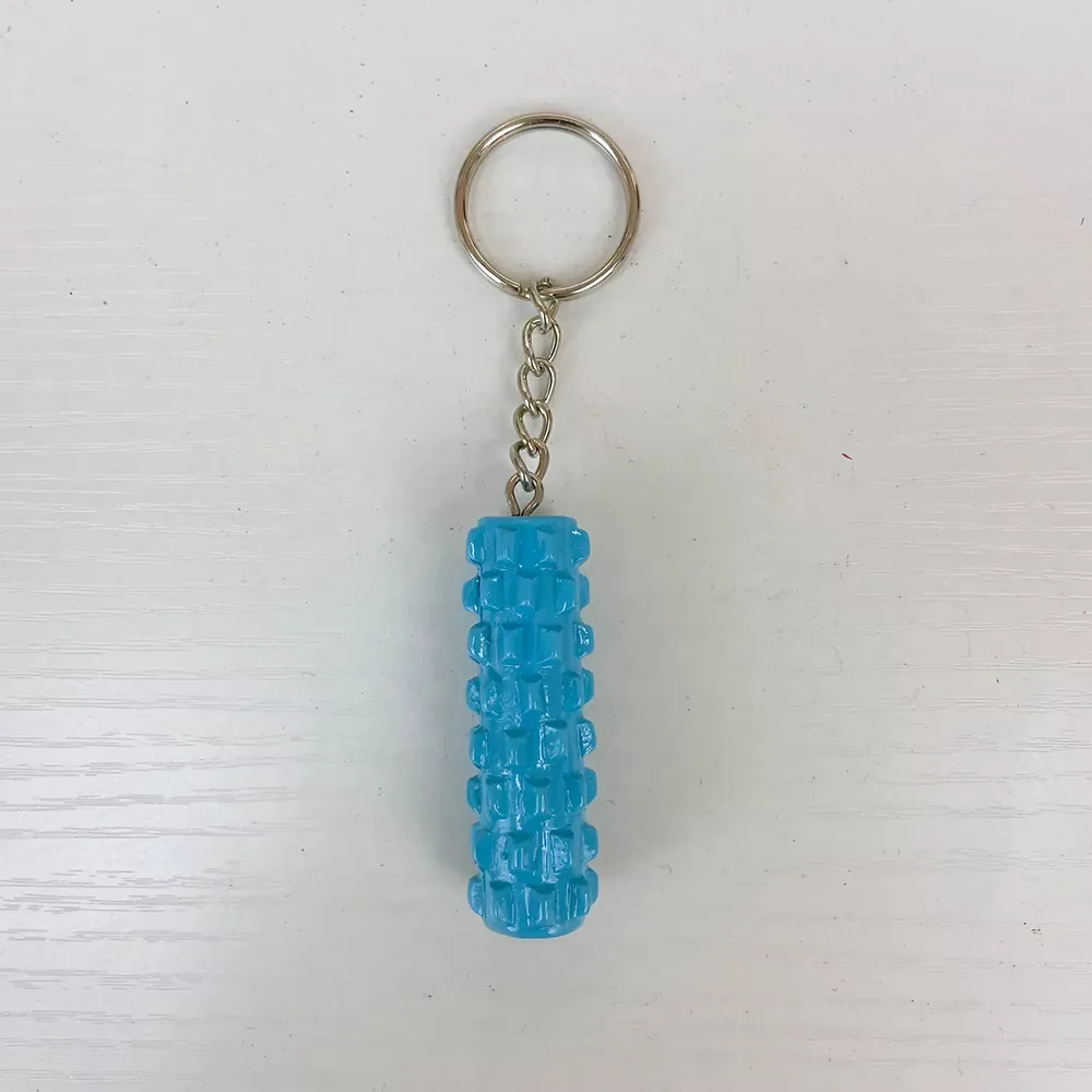 Vista frontal de un llavero de resina con rodillo de espuma azul y textura elevada en cuadrícula con cadena