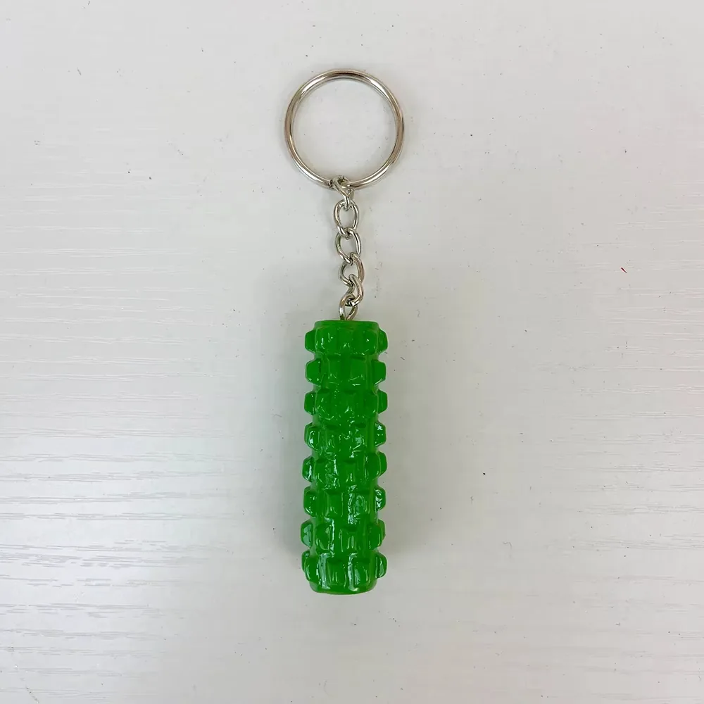 Vista frontal de un llavero de resina con rodillo de espuma verde, cuerpo texturizado y anilla metalica