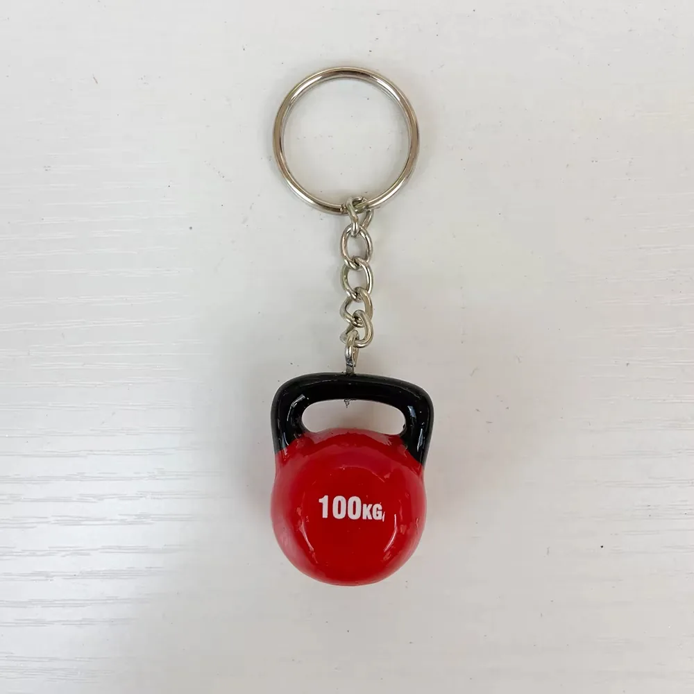 Vista frontal de un llavero de resina con kettlebell roja de 100KG, superficie brillante y asa negra