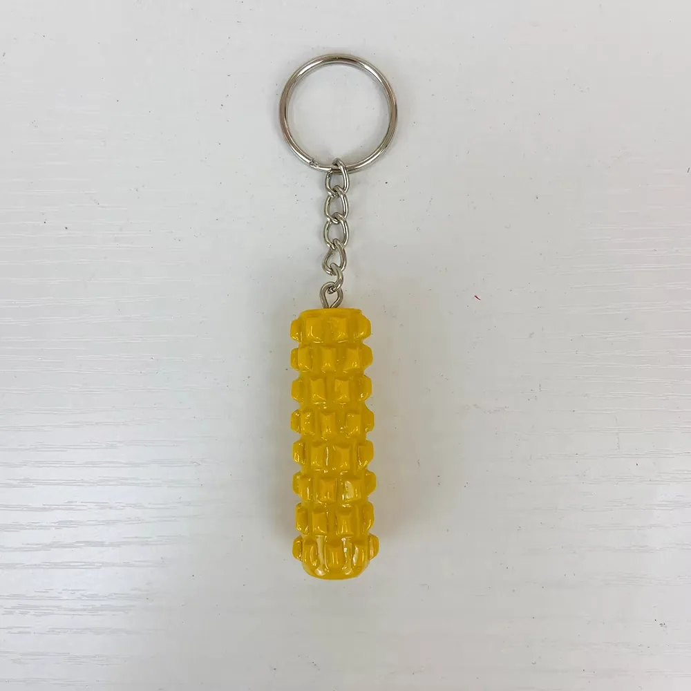 Vista frontal de un llavero de resina con rodillo de espuma amarillo y patron de masaje en relieve
