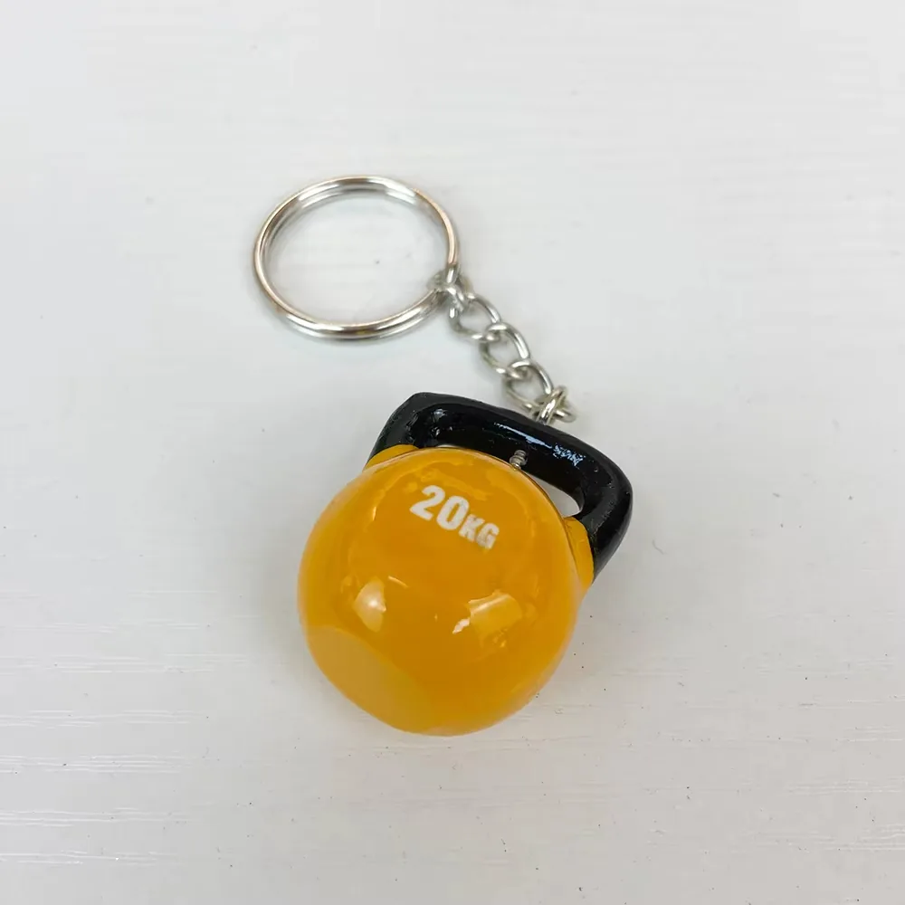Llavero fitness de resina con kettlebell amarilla de 20KG y asa negra visto en angulo
