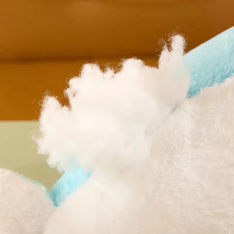 Detalle visible del relleno de algodón PP dentro del cojín de peluche de delfín