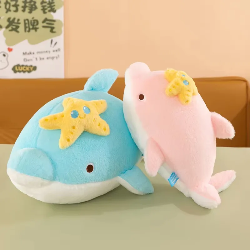 Blue and pink dolphin plush pillows displayed together with smiling yellow starfish appliques on top