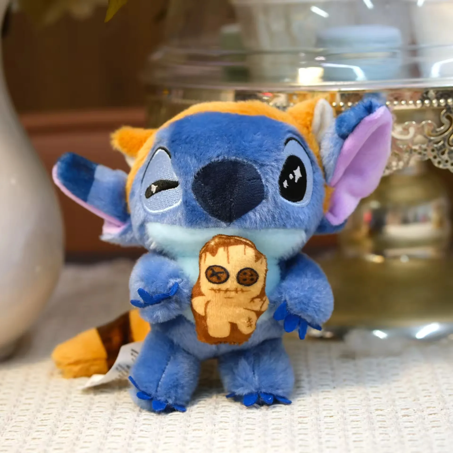 Llavero de peluche Stitch sosteniendo un accesorio de galleta con detalles naranjas temáticos