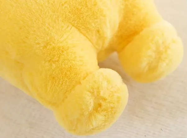 Primer plano de los pies del peluche amarillo Teletubbies mostrando un relleno completo de algodón PP