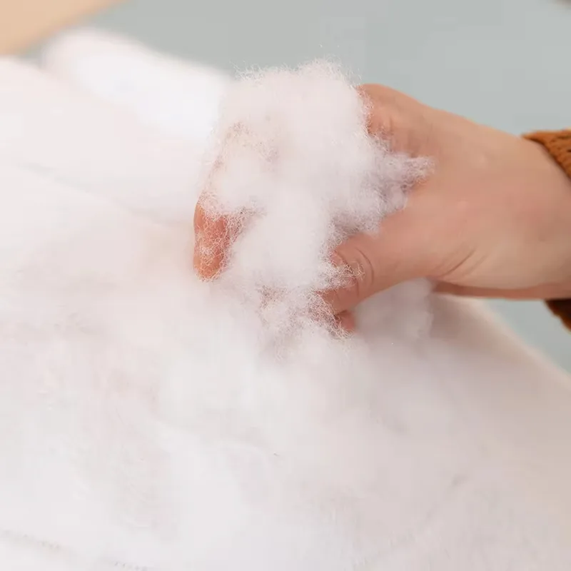 Una mano mostrando el material de relleno blanco usado dentro del cojín de peluche de ballena