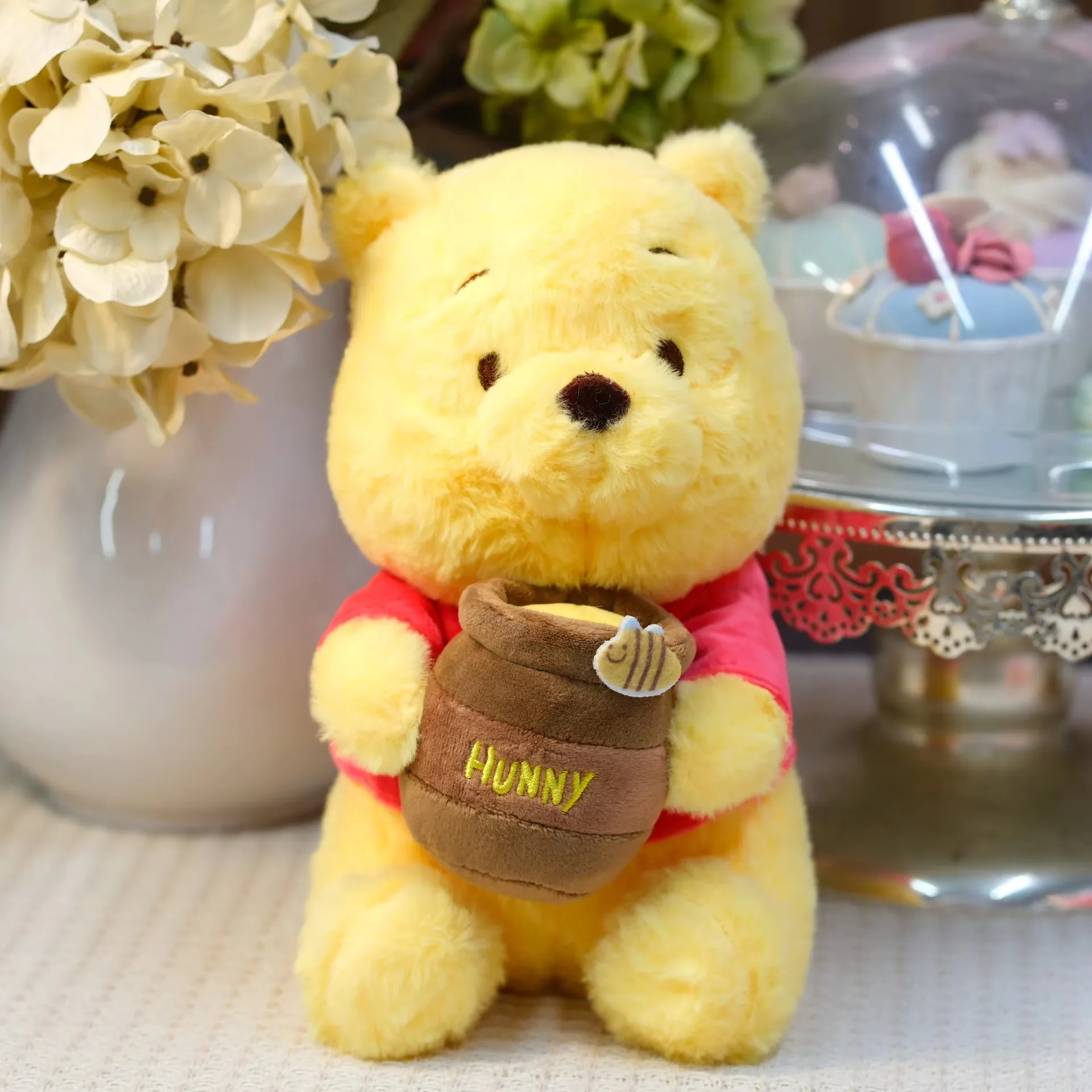 Muñeco de peluche osito con tarro de miel amarillo con camiseta roja y un tarro marrón